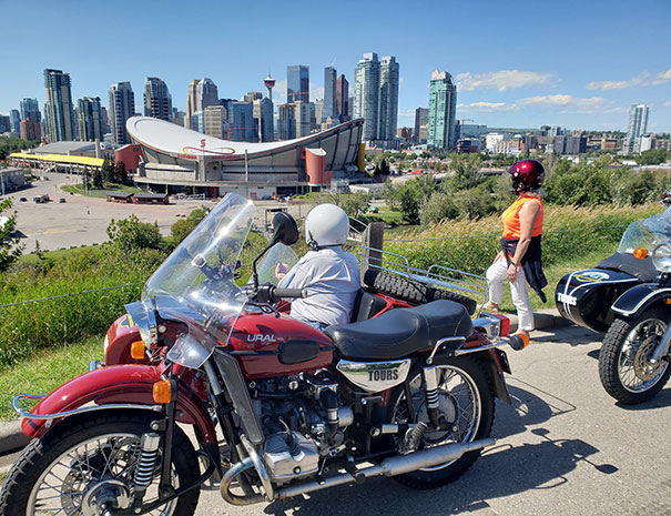 Rocky Mountain Sidecar Adventures Calgary Sightseeing Tour group overlooking the Calgary Saddledome and the city skyline