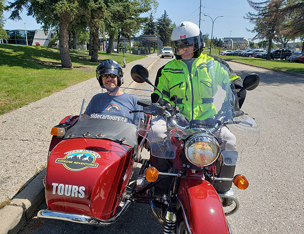 Rocky Mountain Sidecar Adventures Calgary Sightseeing Tour group customer posing in the sidecar