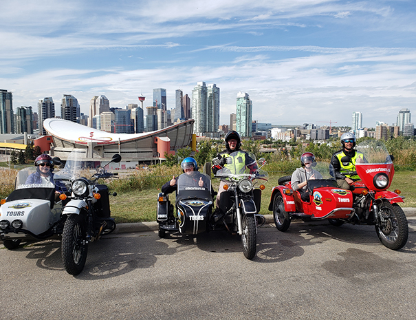 Rocky Mountain Sidecar Adventures Calgary Sightseeing Tour group with Calgary skyline in background
